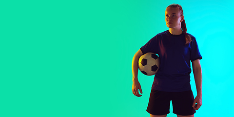 Image showing Female soccer, football player holding ball, posing confident isolated on gradient background. Flyer with copyspace.