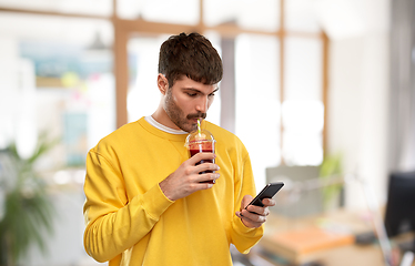 Image showing man with smartphone and tomato juice at office