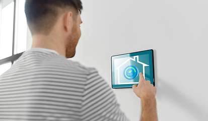 Image showing man looking at tablet computer at smart home