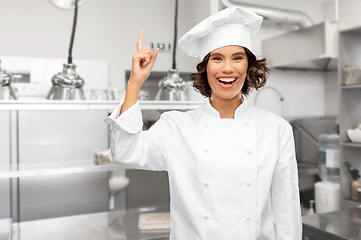 Image showing female chef pointing finger up over restaurant