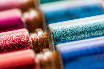 Image showing set of different glitters in small glass bottles