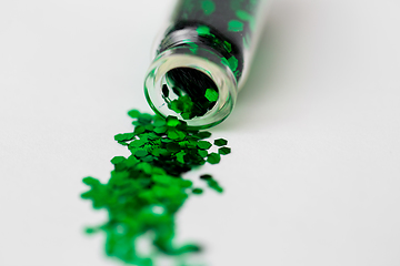 Image showing green glitters poured from small glass bottle