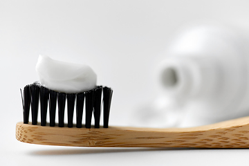 Image showing natural wooden toothbrush with toothpaste on it