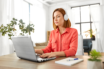 Image showing woman in headphones with laptop working at home