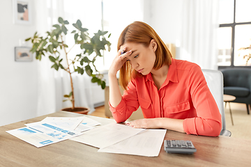 Image showing woman with calculator and papers working at home