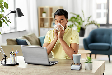 Image showing indian man with laptop blowing nose at home office