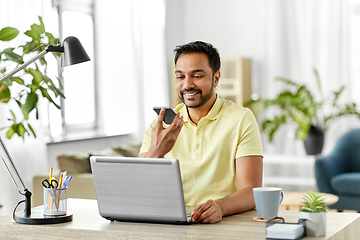 Image showing man recording voice on smartphone at home office