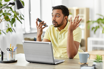 Image showing man recording voice on smartphone at home office