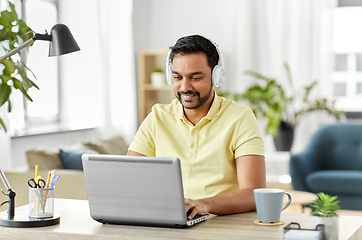 Image showing man in headphones with laptop working at home