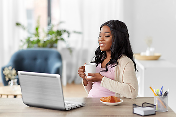 Image showing happy woman with laptop and coffee at home office