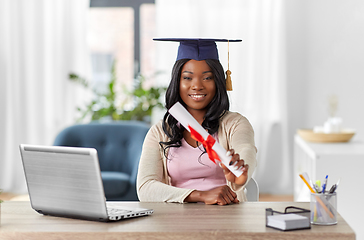 Image showing graduate student with laptop and diploma at home