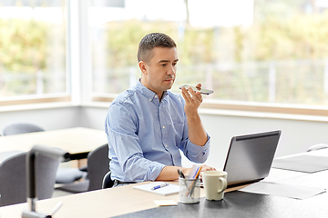 Image showing man with smartphone and laptop at home office