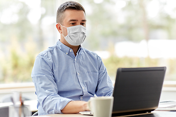 Image showing man in mask with laptop working at home office