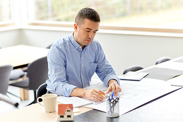 Image showing architect with blueprint working at home office