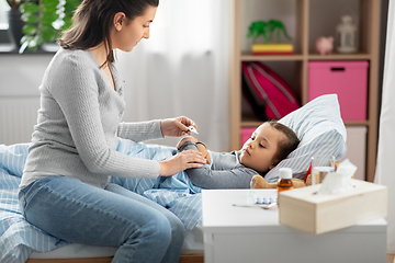 Image showing mother measuring temperature of sick daughter