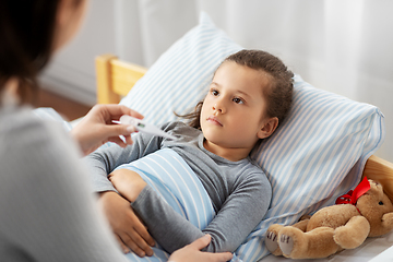 Image showing mother measuring temperature of sick daughter