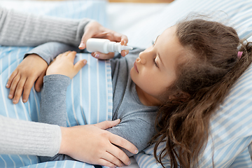 Image showing mother with nasal spray treats sick daughter