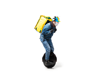 Image showing Too much orders. Contacless delivery service during quarantine. Man delivers food and shopping bags during isolation, wearing gloves and face mask.