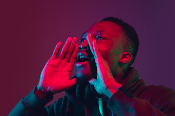 Image showing African-american man\'s portrait isolated on gradient studio background in neon light