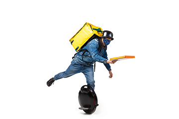 Image showing Too much orders. Contacless delivery service during quarantine. Man delivers food and shopping bags during isolation, wearing gloves and face mask.