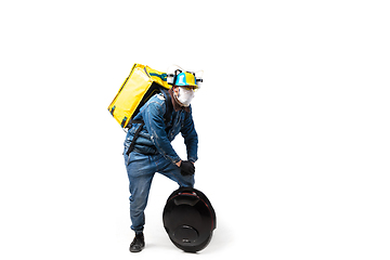 Image showing Too much orders. Contacless delivery service during quarantine. Man delivers food and shopping bags during isolation, wearing gloves and face mask.