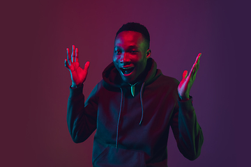 Image showing African-american man\'s portrait isolated on gradient studio background in neon light