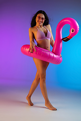 Image showing Fashion portrait of young fit and sportive woman in purple luxury swimwear and stylish sunglasses on gradient background. Perfect body ready for summertime.