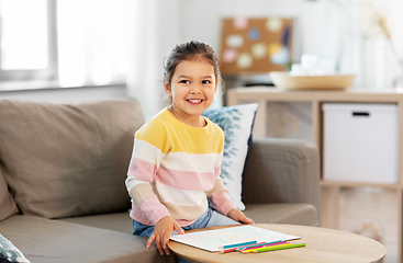 Image showing little girl drawing with coloring pencils at home