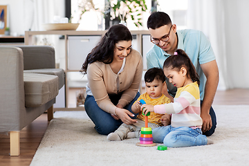 Image showing happy family playing with pyramid toy at home