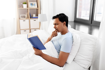 Image showing indian man reading book in bed at home