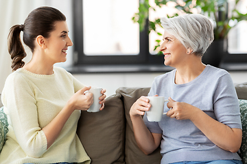 Image showing senior mother and adult daughter drinking coffee