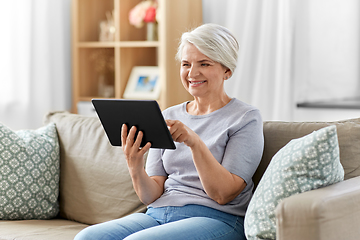 Image showing happy senior woman with tablet pc at home