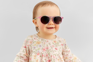Image showing happy little baby girl in sunglasses over grey