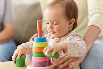 Image showing lovely baby girl playing with toy pyramid at home