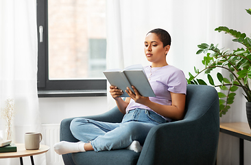 Image showing african american woman reading book at home