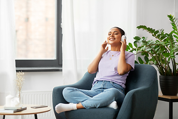 Image showing woman in headphones listening to music at home