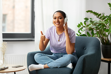 Image showing woman in headphones listening to music at home