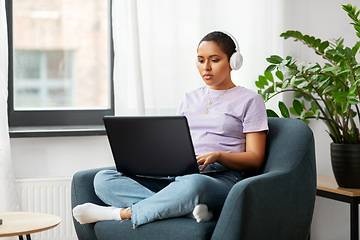 Image showing woman with laptop listening to music at home