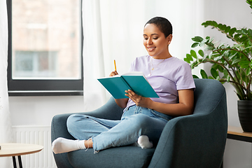 Image showing happy african american woman with diary at home