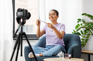 Image showing female beauty blogger with camera and mascara