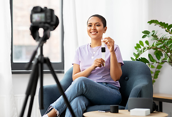 Image showing female blogger with camera video blogging at home