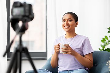 Image showing female blogger with camera and coffee at home