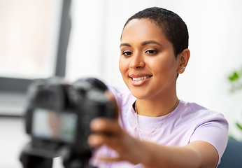 Image showing female video blogger adjusting camera at home