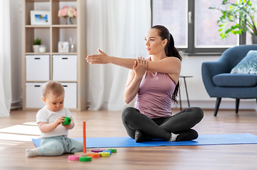 Image showing happy mother with little baby exercising at home