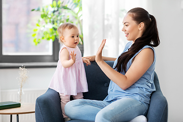 Image showing happy mother playing with baby daughter at home