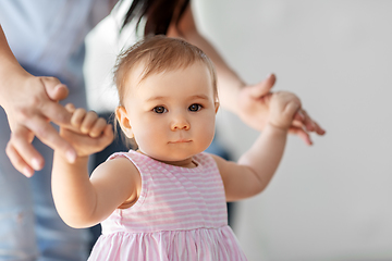 Image showing baby girl learning to walk with mother's help