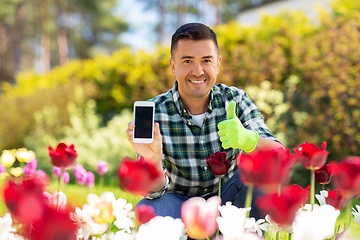 Image showing man with phone showing thumbs up at flowers garden