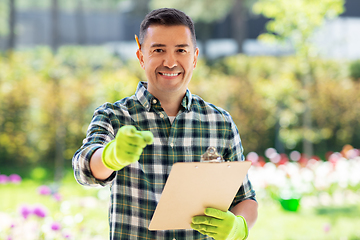 Image showing happy smiling man with clipboard at summer garden