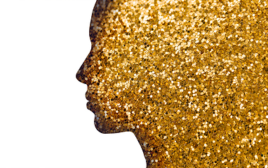 Image showing silhouette of woman face on golden glitters