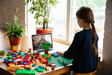 Image showing Girl playing with constructor at home, watching teacher\'s tutorial on laptop. Digitalization, remote education